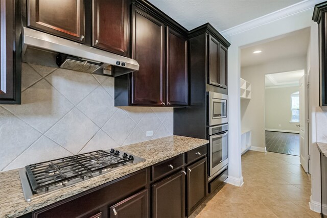 13918 Twisting Ivy Ln, Cypress, TX 77429 - kitchen featuring under cabinet range hood, appliances with stainless steel finishes, ornamental molding, tasteful backsplash, and baseboards