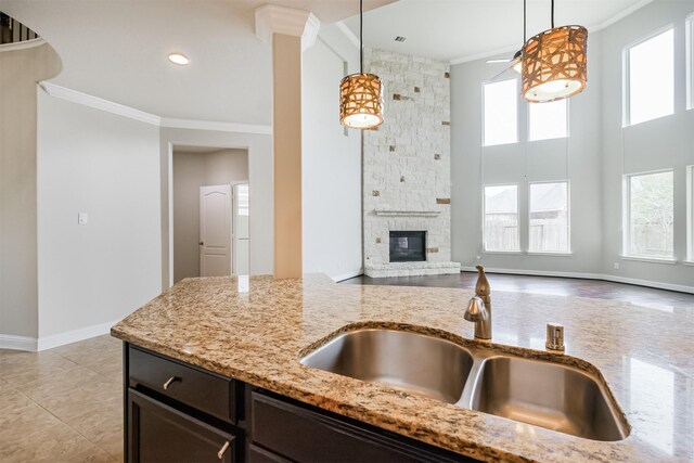 13918 Twisting Ivy Ln, Cypress, TX 77429 - kitchen featuring a sink, crown molding, light stone countertops, baseboards, and ceiling fan