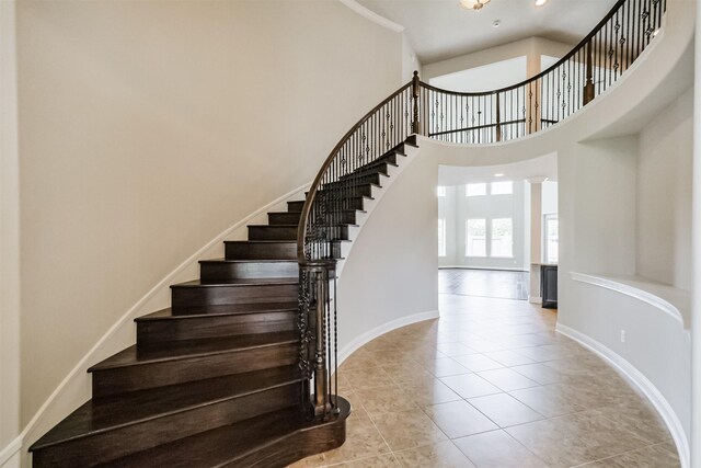 13918 Twisting Ivy Ln, Cypress, TX 77429 - staircase featuring tile patterned floors, a high ceiling, and baseboards
