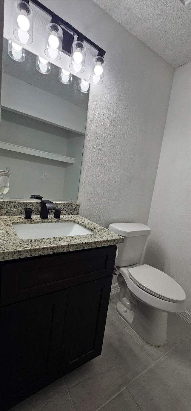 12819 Carvel Ln, Houston, TX 77072 - bathroom featuring a textured ceiling, toilet, vanity, tile patterned floors, and baseboards