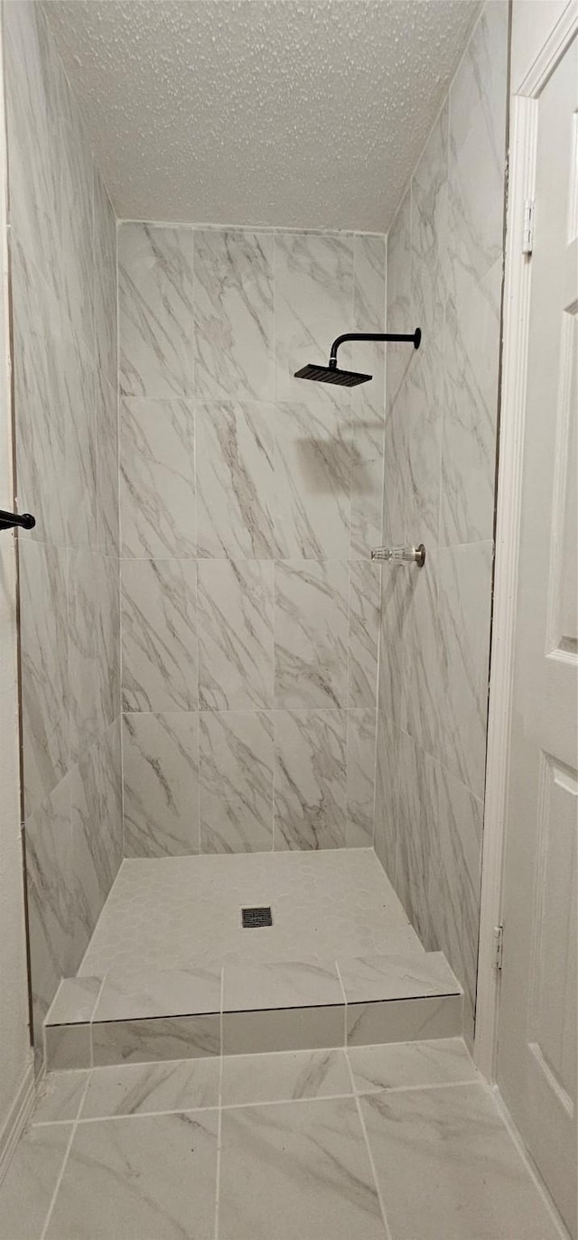 12819 Carvel Ln, Houston, TX 77072 - full bath with a tile shower, a textured ceiling, and marble look tiles