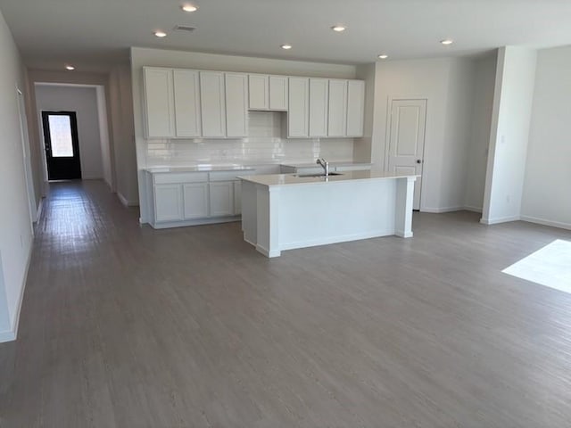 419 Robin St, Angleton, TX 77515 - kitchen featuring a kitchen island with sink, baseboards, a sink, decorative backsplash, and wood finished floors