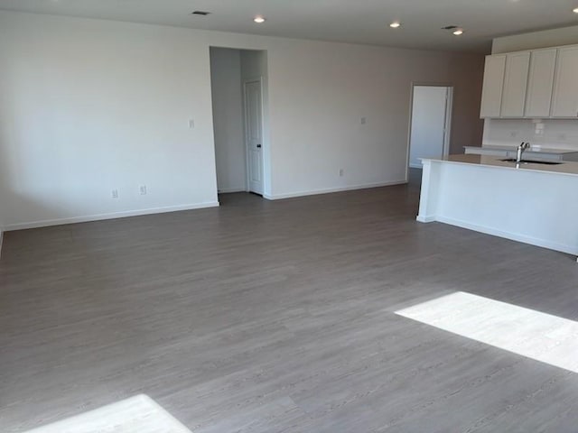 419 Robin St, Angleton, TX 77515 - kitchen with baseboards, open floor plan, white cabinetry, wood finished floors, and recessed lighting