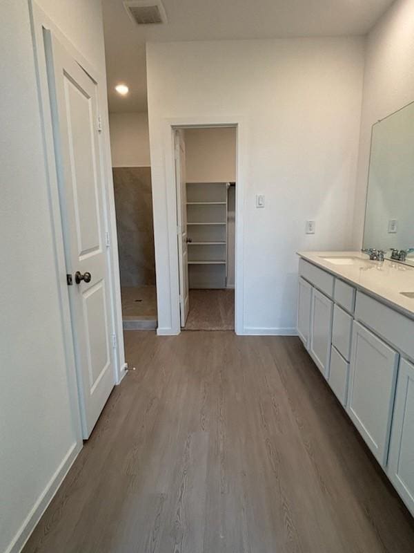 419 Robin St, Angleton, TX 77515 - full bathroom featuring double vanity, wood finished floors, baseboards, a shower, and a walk in closet