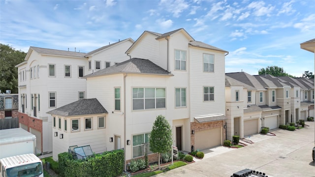 1210 Cedarpost Tree Springs Pl Unit P, Houston, TX 77055 - view of property featuring an attached garage, driveway, a residential view, a shingled roof, and stucco siding