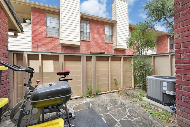 2211 S Kirkwood Rd Unit 26, Houston, TX 77077 - view of patio / terrace with cooling unit, asphalt driveway, grilling area, and a garage