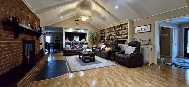 1 Lazy Ln, Bay City, TX 77414 - living area featuring wood finished floors, a fireplace, ceiling fan, beamed ceiling, and built in shelves