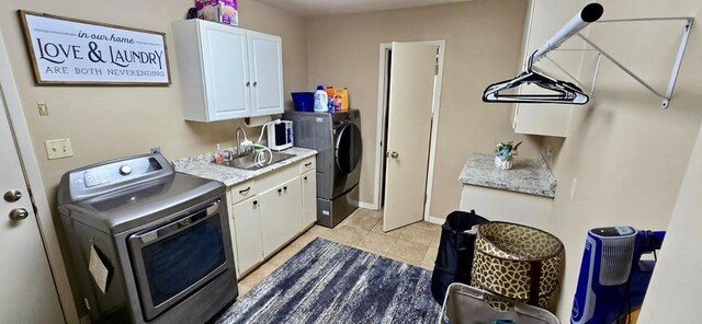 1 Lazy Ln, Bay City, TX 77414 - laundry area with cabinet space, light tile patterned floors, washing machine and clothes dryer, and baseboards