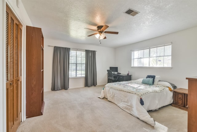 1805 Twila Ln, Conroe, TX 77301 - bedroom featuring multiple windows, light colored carpet, a textured ceiling, a ceiling fan, and a closet
