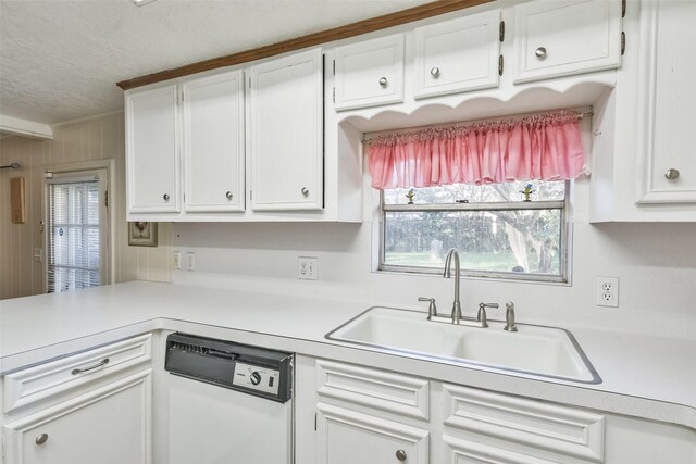 1805 Twila Ln, Conroe, TX 77301 - kitchen featuring white dishwasher, a sink, a textured ceiling, light countertops, and white cabinets
