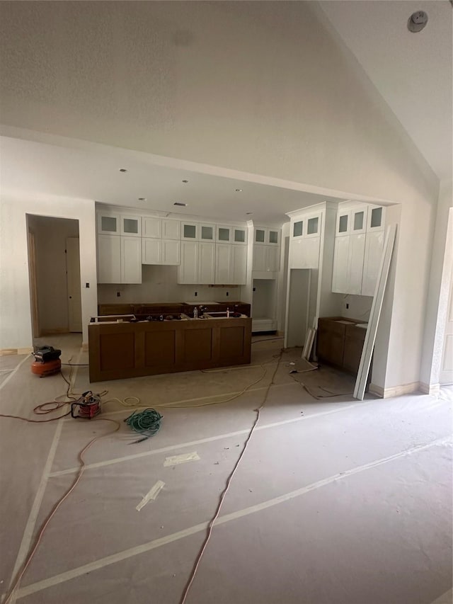 2439 Centurian Cir, Roman Forest, TX 77357 - kitchen with white cabinets, glass insert cabinets, baseboards, a high ceiling, and a center island