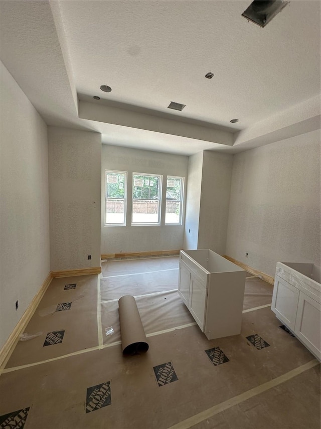 2439 Centurian Cir, Roman Forest, TX 77357 - unfurnished room featuring a raised ceiling, baseboards, and a textured ceiling