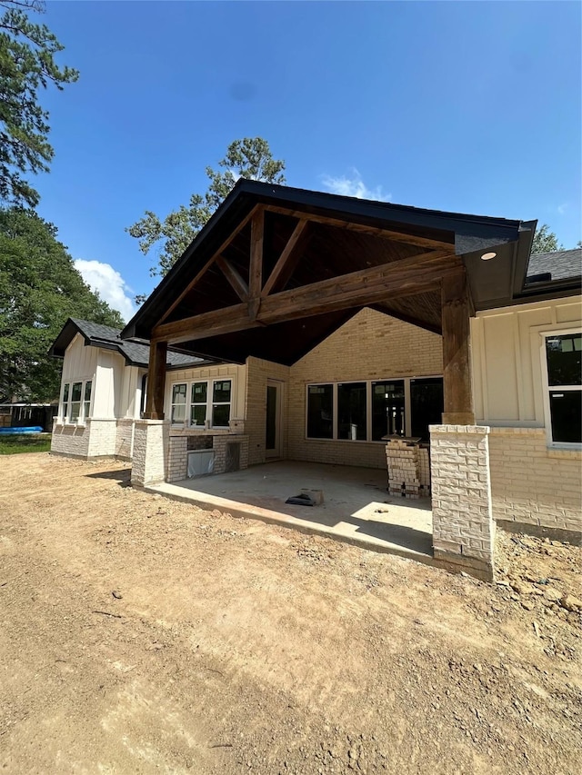 2439 Centurian Cir, Roman Forest, TX 77357 - rear view of property featuring a patio area, board and batten siding, and brick siding