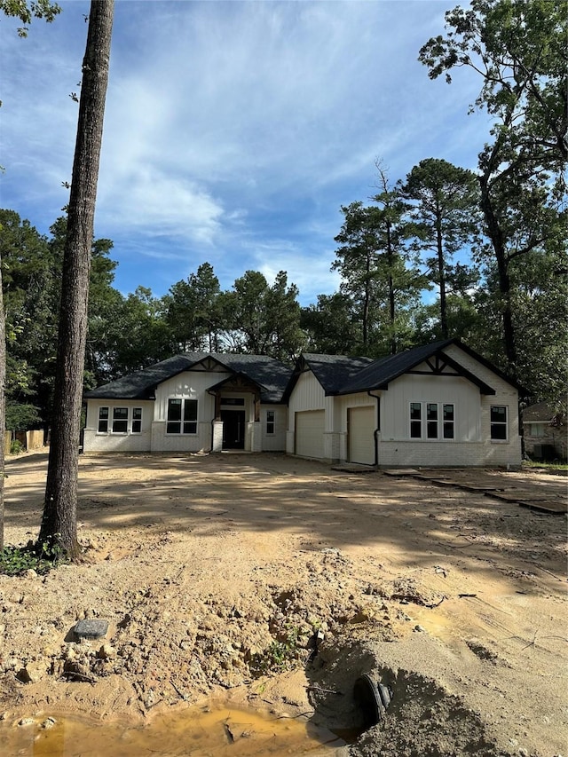 2439 Centurian Cir, Roman Forest, TX 77357 - view of front of home with a garage, driveway, and view of wooded area