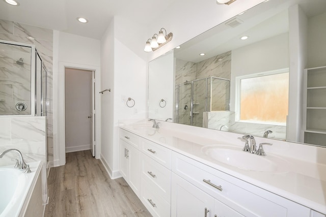 7974 Fowlie St, Houston, TX 77028 - bathroom featuring a marble finish shower, double vanity, a garden tub, wood finished floors, and recessed lighting