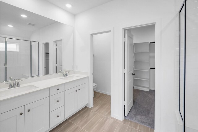 5210 Lake Trout Ln, Baytown, TX 77521 - bathroom featuring toilet, double vanity, a spacious closet, a shower stall, and recessed lighting