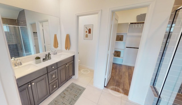 5210 Lake Trout Ln, Baytown, TX 77521 - bathroom featuring toilet, a walk in closet, double vanity, a stall shower, and tile patterned floors