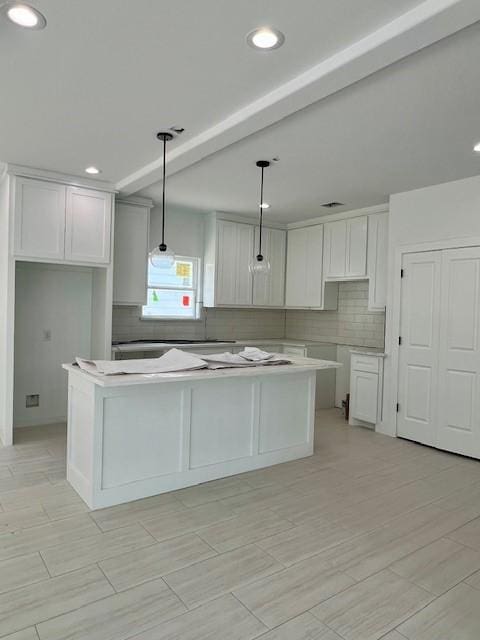 7107 Foster St Unit A, Houston, TX 77021 - kitchen featuring tasteful backsplash, white cabinets, a kitchen island, recessed lighting, and decorative light fixtures