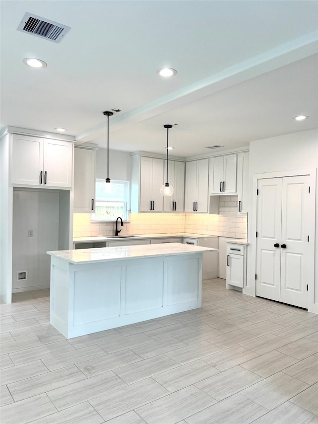 7107 Foster St Unit A, Houston, TX 77021 - kitchen featuring a center island, tasteful backsplash, recessed lighting, decorative light fixtures, and white cabinets