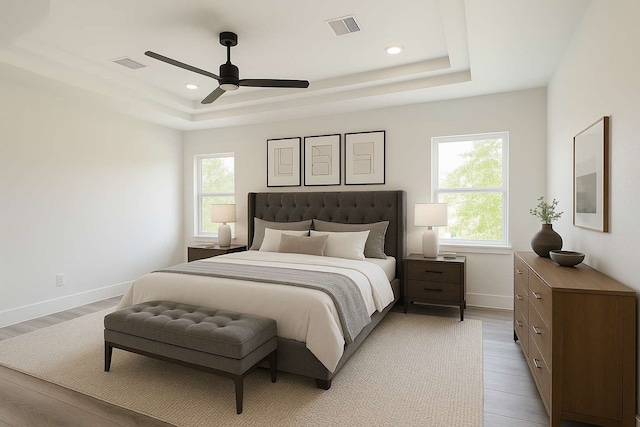 7107 Foster St Unit A, Houston, TX 77021 - bedroom with a tray ceiling, multiple windows, light wood-style flooring, recessed lighting, and ceiling fan
