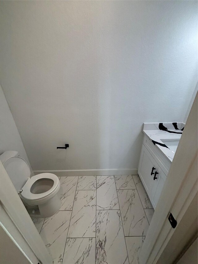 6197 Rd 5503, Cleveland, TX 77327 - bathroom featuring marble look tile flooring, baseboards, vanity, and toilet