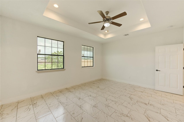 6197 Rd 5503, Cleveland, TX 77327 - unfurnished room featuring a tray ceiling, a ceiling fan, recessed lighting, marble look tile flooring, and baseboards