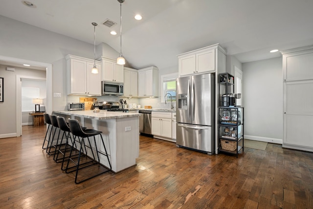 2107 Hewitt Dr, Houston, TX 77018 - kitchen with stainless steel appliances, a kitchen breakfast bar, vaulted ceiling, white cabinets, and backsplash