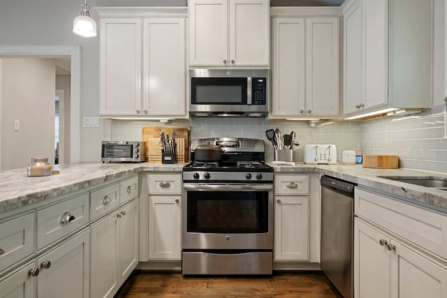 2107 Hewitt Dr, Houston, TX 77018 - kitchen with stainless steel appliances, tasteful backsplash, light stone counters, and hanging light fixtures