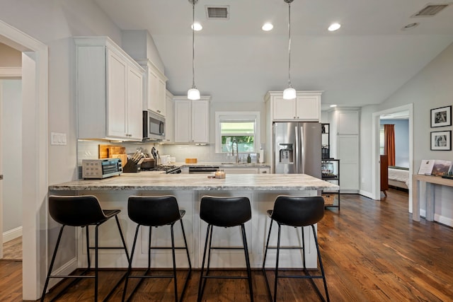 2107 Hewitt Dr, Houston, TX 77018 - kitchen with appliances with stainless steel finishes, lofted ceiling, a peninsula, tasteful backsplash, and white cabinets