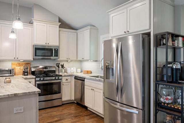2107 Hewitt Dr, Houston, TX 77018 - kitchen featuring stainless steel appliances, lofted ceiling, decorative backsplash, dark wood-type flooring, and light stone counters