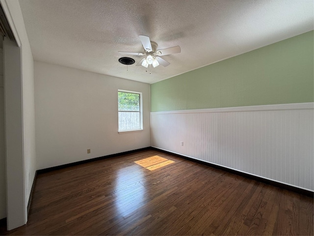 2016 N Tinsley St, Angleton, TX 77515 - empty room with wood finished floors, a ceiling fan, a wainscoted wall, a textured ceiling, and baseboards
