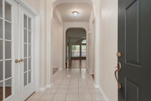 30 Teak Mill Pl, The Woodlands, TX 77382 - entryway with arched walkways, light tile patterned floors, and baseboards