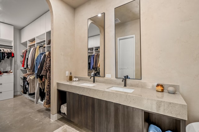 11736 Canyon Ct, Conroe, TX 77385 - full bath with finished concrete flooring, double vanity, and a walk in closet
