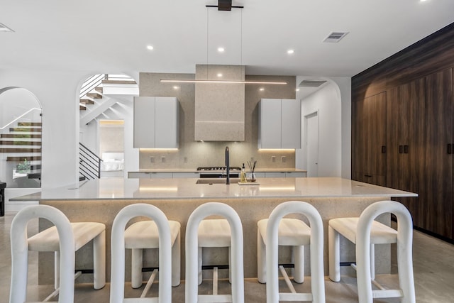 11736 Canyon Ct, Conroe, TX 77385 - kitchen with modern cabinets, a sink, backsplash, a kitchen breakfast bar, and recessed lighting