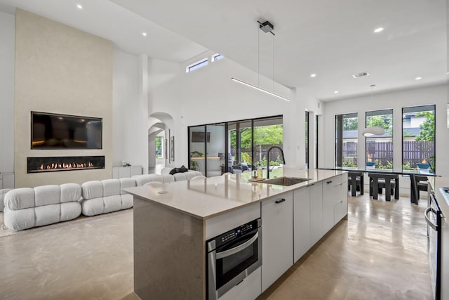 11736 Canyon Ct, Conroe, TX 77385 - kitchen featuring a sink, concrete flooring, modern cabinets, oven, and open floor plan