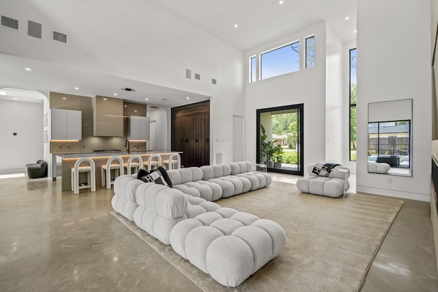 11736 Canyon Ct, Conroe, TX 77385 - living room with concrete flooring, a high ceiling, and recessed lighting