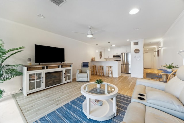 12500 Melville Dr Unit 114B, Montgomery, TX 77356 - living area featuring light wood finished floors, a ceiling fan, and baseboards