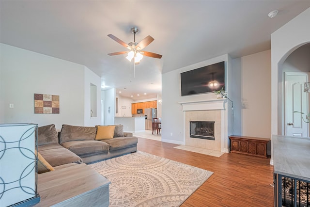 723 Hinsdale, Magnolia, TX 77354 - living room with light wood finished floors, ceiling fan, arched walkways, a tile fireplace, and recessed lighting