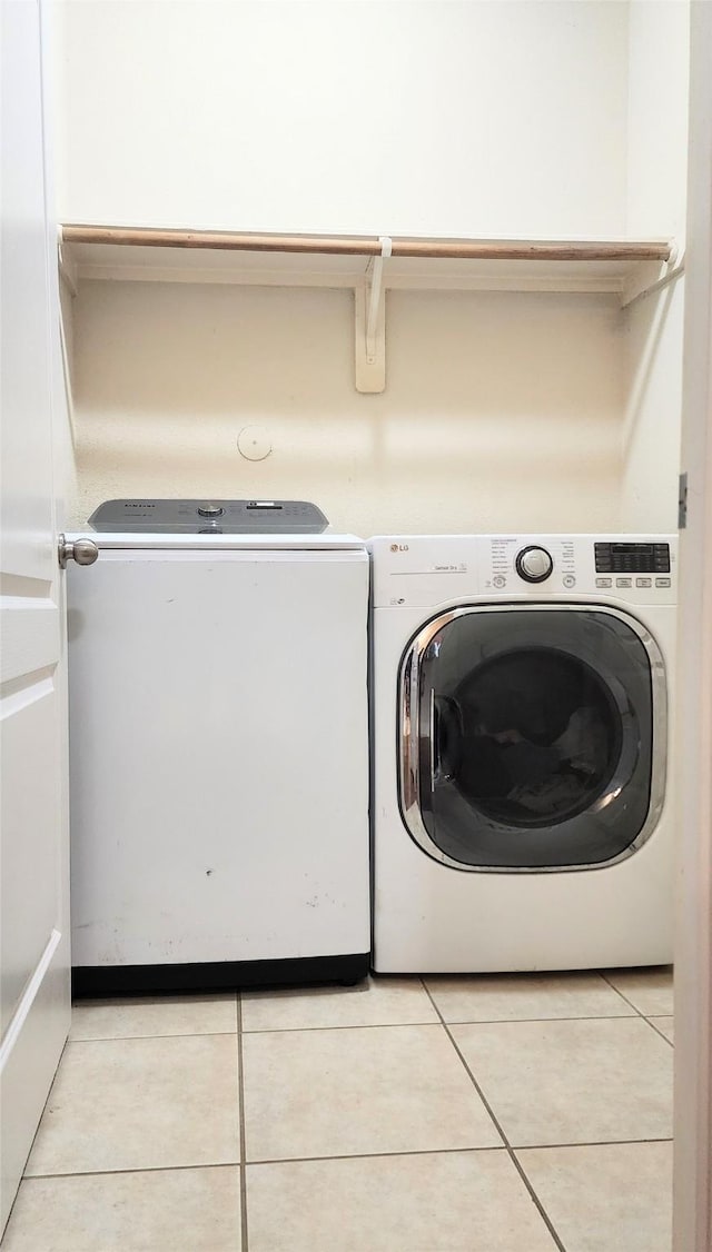 723 Hinsdale, Magnolia, TX 77354 - laundry room featuring washing machine and dryer and light tile patterned floors