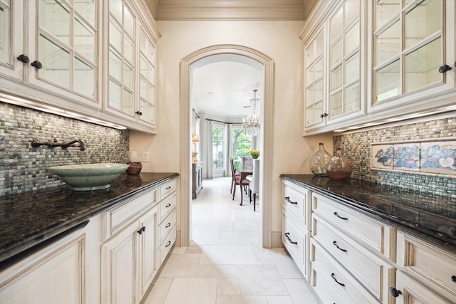 3019 Sunset Blvd, Houston, TX 77005 - bar with ornamental molding, decorative backsplash, a sink, a chandelier, and arched walkways