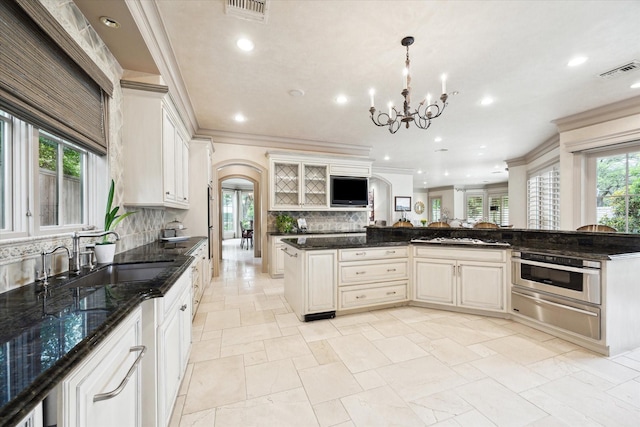 3019 Sunset Blvd, Houston, TX 77005 - kitchen featuring a sink, a warming drawer, backsplash, arched walkways, and crown molding
