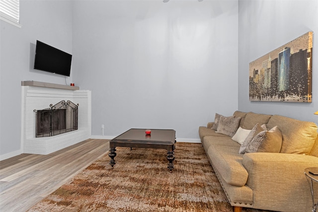 4220 Kenbrook Dr, Nacogdoches, TX 75965 - living area featuring wood finished floors, a towering ceiling, baseboards, and a fireplace