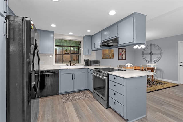 4220 Kenbrook Dr, Nacogdoches, TX 75965 - kitchen featuring black appliances, a peninsula, gray cabinetry, light wood-style flooring, and recessed lighting