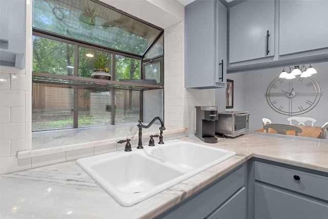 4220 Kenbrook Dr, Nacogdoches, TX 75965 - kitchen with gray cabinets, a sink, healthy amount of natural light, and light stone countertops