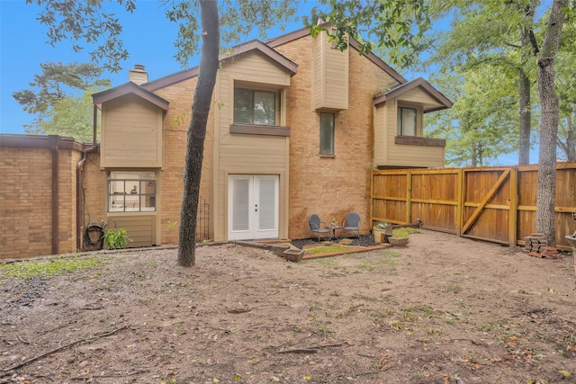 4220 Kenbrook Dr, Nacogdoches, TX 75965 - view of front of home featuring a chimney, brick siding, french doors, and a gate