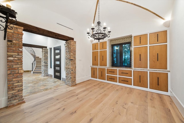 721 Harborside Way, League City, TX 77565 - unfurnished living room featuring light wood-style flooring, a chandelier, stairway, baseboards, and high vaulted ceiling
