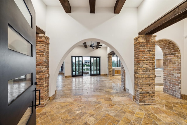 721 Harborside Way, League City, TX 77565 - foyer entrance featuring stone tile floors, arched walkways, beamed ceiling, a ceiling fan, and a towering ceiling