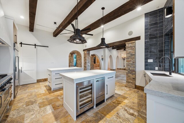 721 Harborside Way, League City, TX 77565 - kitchen featuring a sink, wine cooler, stone tile floors, ceiling fan, and a barn door