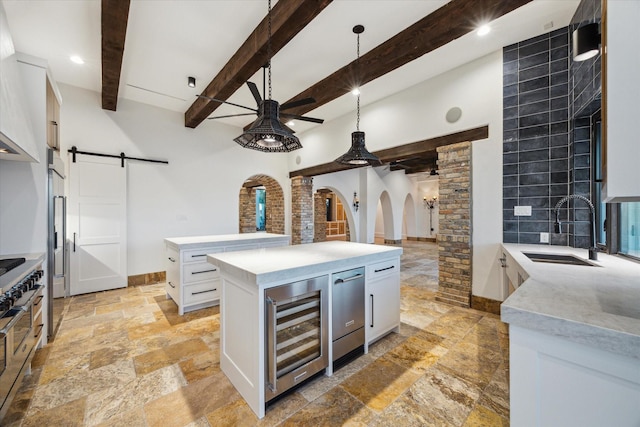 721 Harborside Way, League City, TX 77565 - kitchen featuring a sink, wine cooler, stone tile floors, ceiling fan, and a barn door