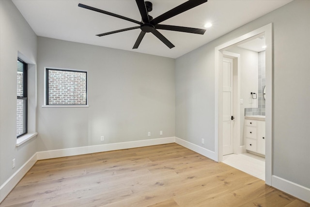 721 Harborside Way, League City, TX 77565 - unfurnished bedroom featuring light wood-style floors, multiple windows, baseboards, recessed lighting, and ensuite bathroom